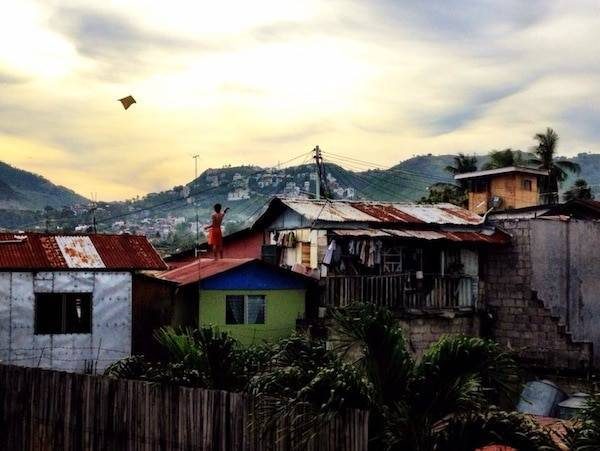 Flying a kite over some buildings.