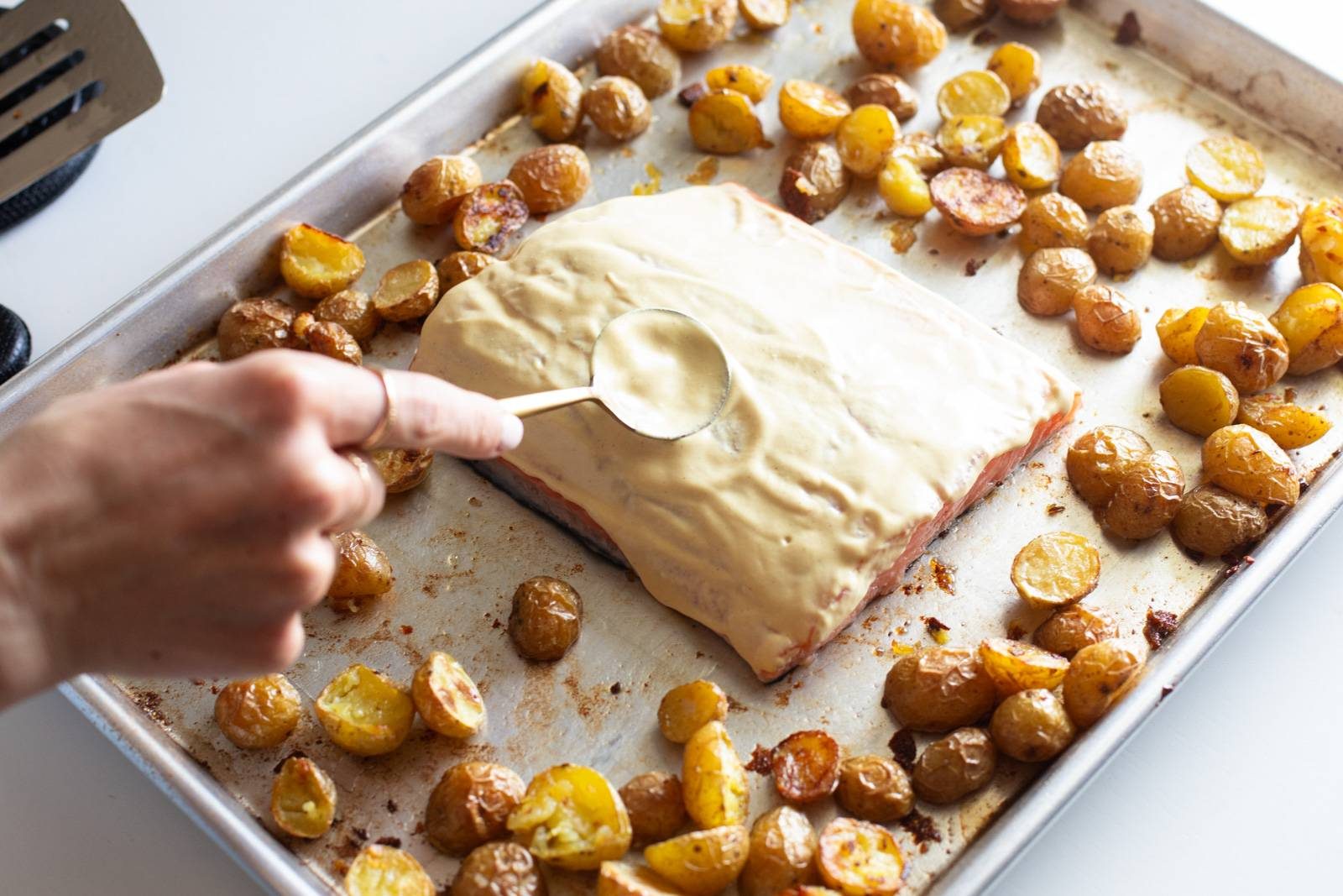 Salmon and potatoes on a sheet pan before cooking.