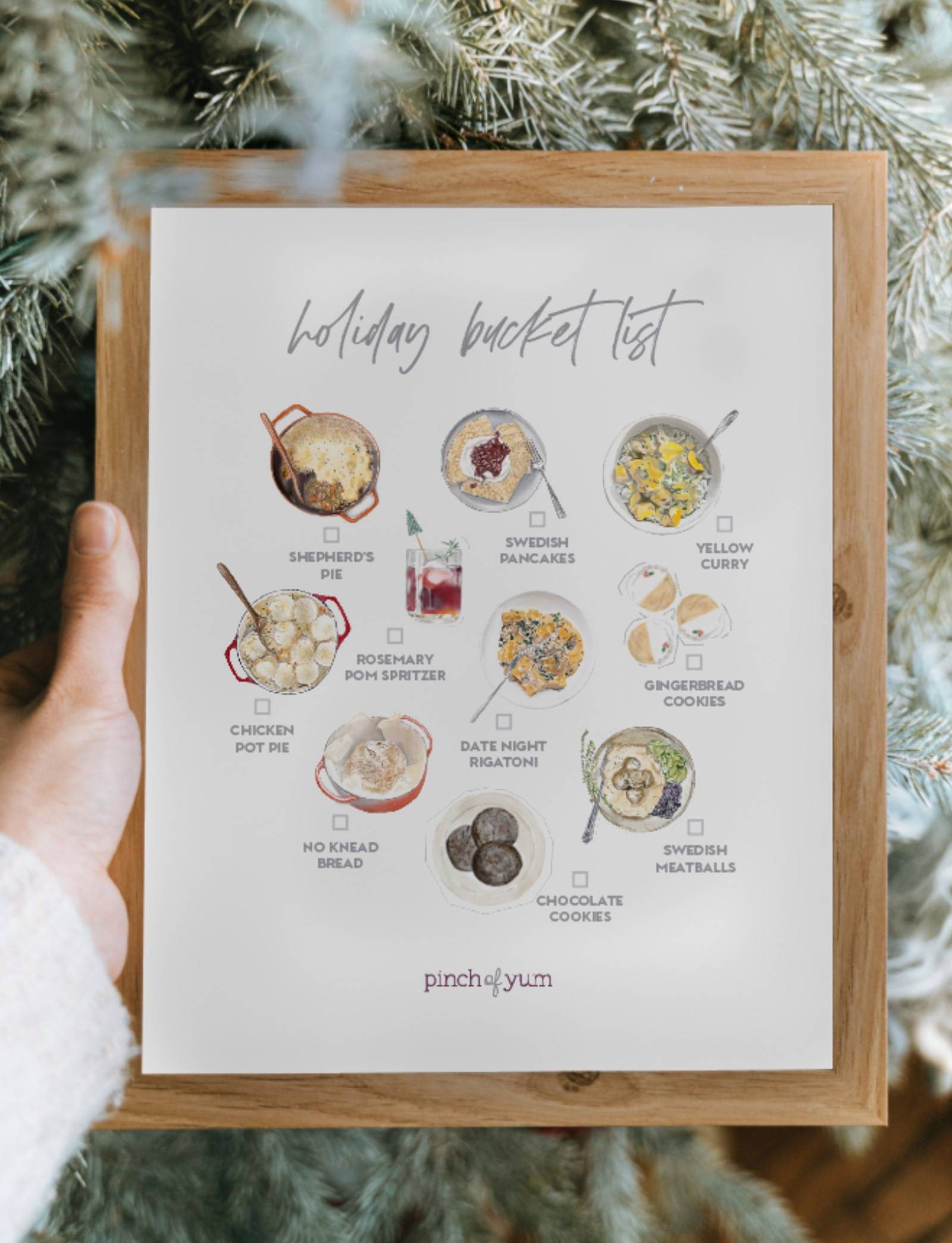 Holiday bucket list in a frame with a holiday tree.