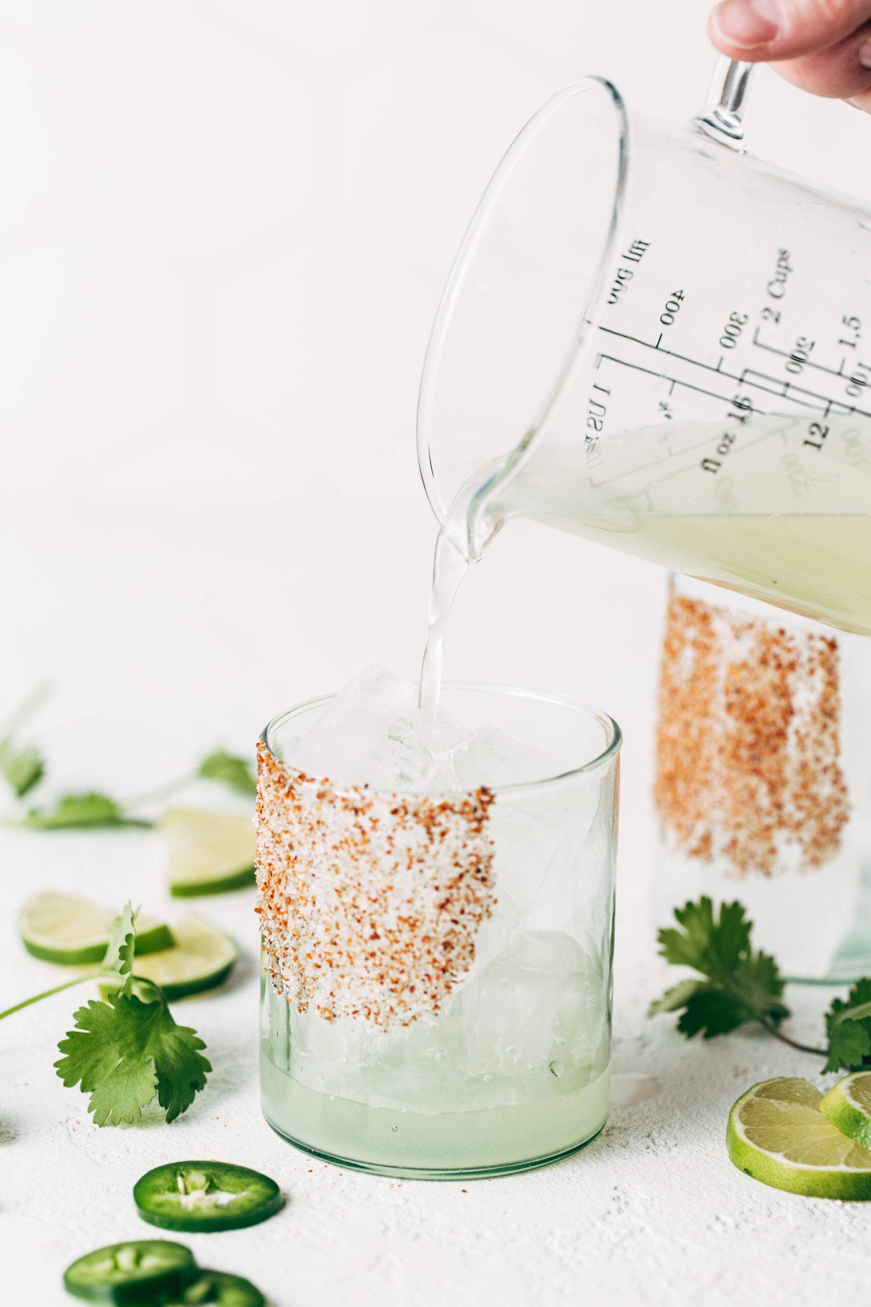 White hand pouring non-alcoholic margaritas into a glass