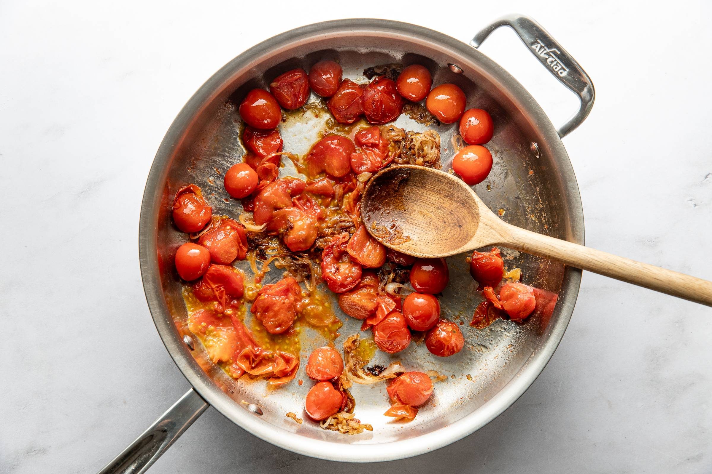 Smashing tomatoes in a pan.